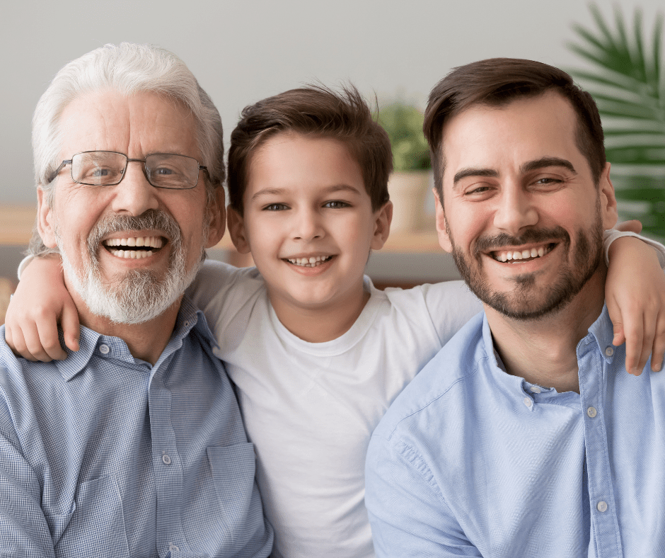 Three generations smiling warmly together: a grandfather, father, and grandson, highlighting joyful family connections.