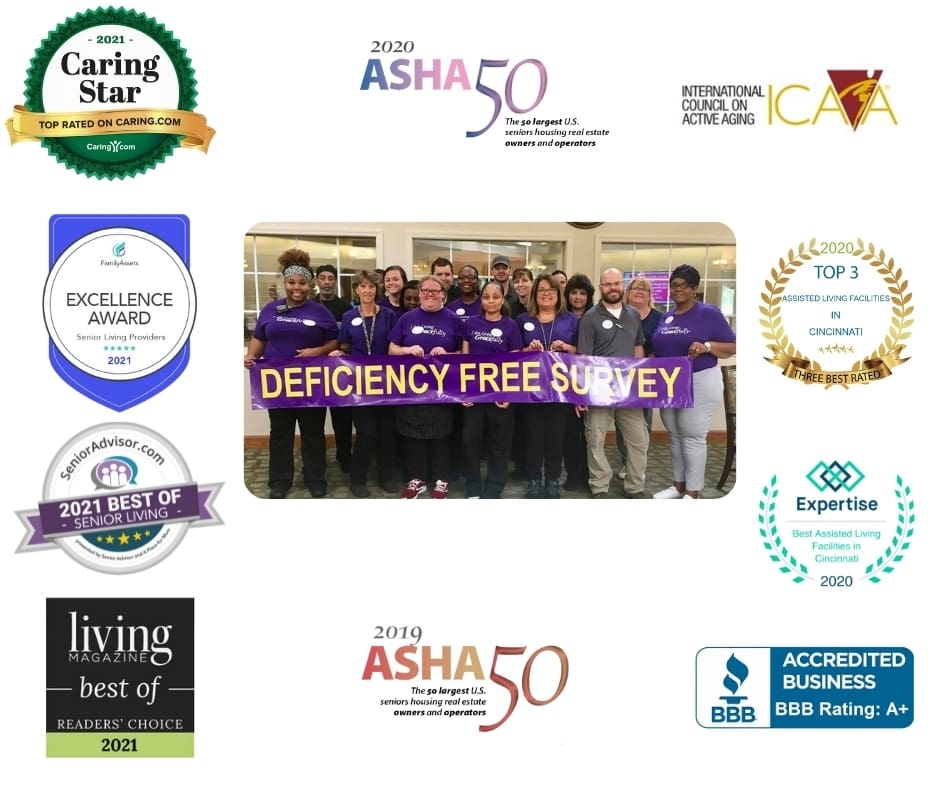A diverse group of staff members in purple shirts proudly holds a banner reading DEFICIENCY FREE SURVEY in a welcoming common area.