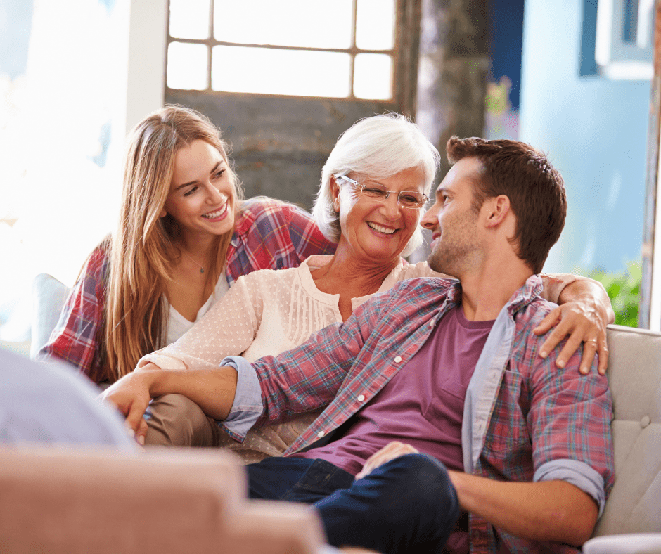 Three family members share joyful moments together on a comfortable couch, fostering connection and warmth in a cozy living space.