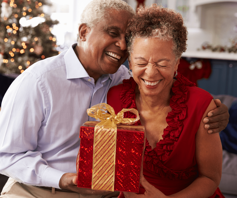 Joyful couple celebrating together, sharing a gift amid a festive, decorated setting, radiating warmth and connection.