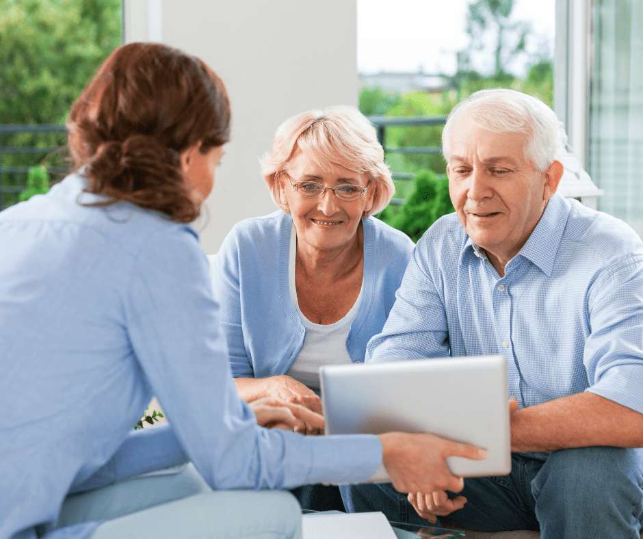 Engaging discussion between a compassionate caregiver and a cheerful senior couple, showcasing supportive interaction.