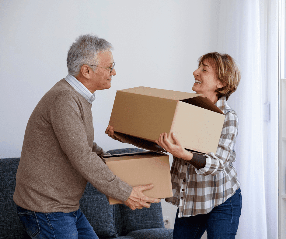 A joyful couple collaborates in unpacking moving boxes in a bright, inviting living space.