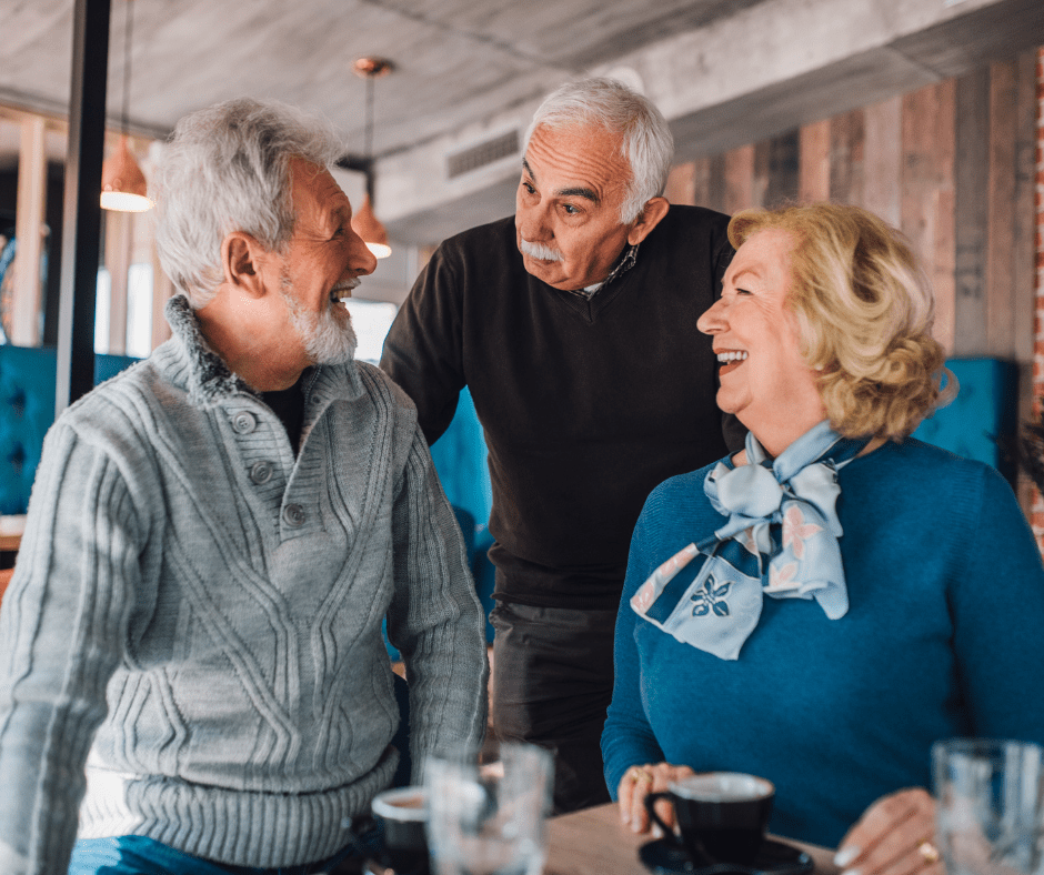 Seniors engaging in cheerful conversation over coffee in a cozy, upscale café setting, showcasing warmth and companionship.