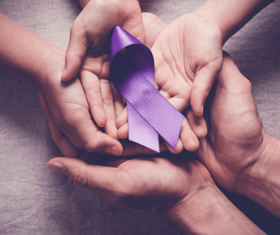 Hands of multiple generations gently hold a purple ribbon, symbolizing support and compassion.