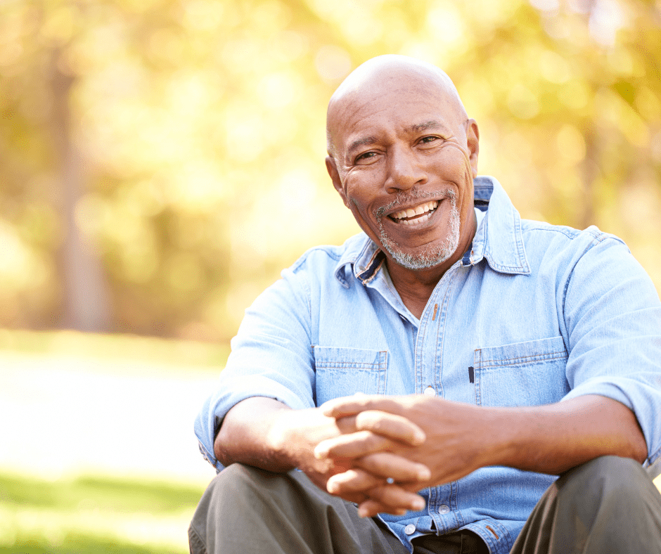 Senior man smiling with trees in the background
