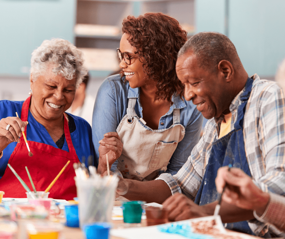 Residents joyfully painting together, showcasing vibrant creativity and community spirit in a warm, supportive environment.