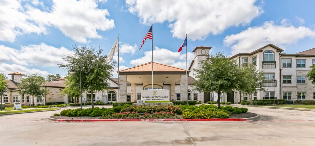 Welcoming entrance of Woodhaven Village, showcasing well-maintained grounds, upscale architecture, and vibrant community spirit.
