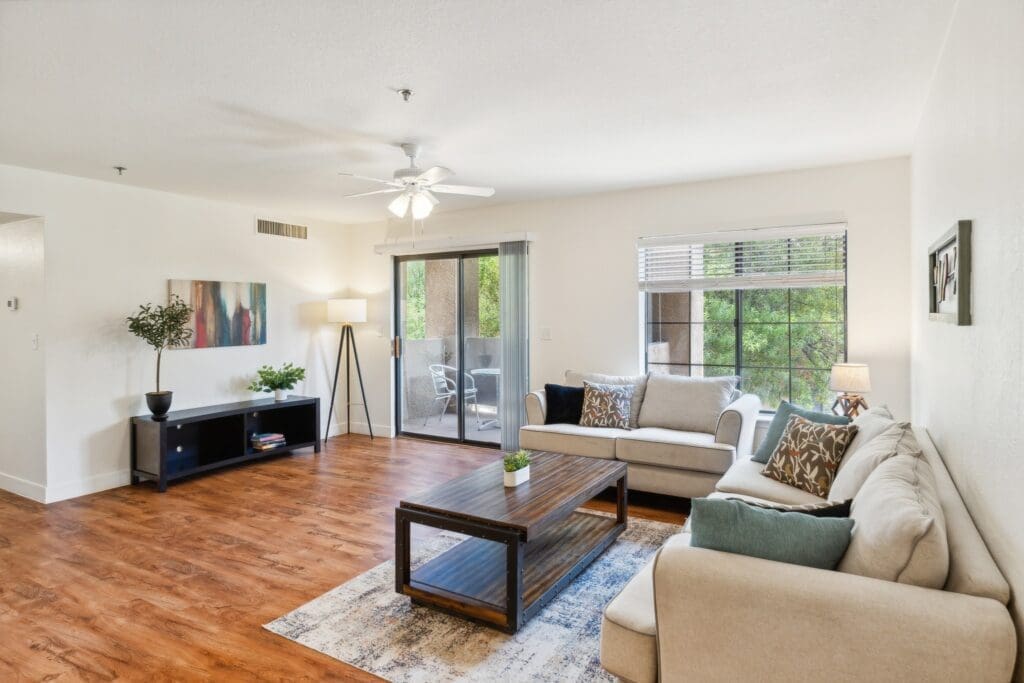 Light-filled living room featuring elegant furnishings, a stylish coffee table, and views of a serene outdoor space.