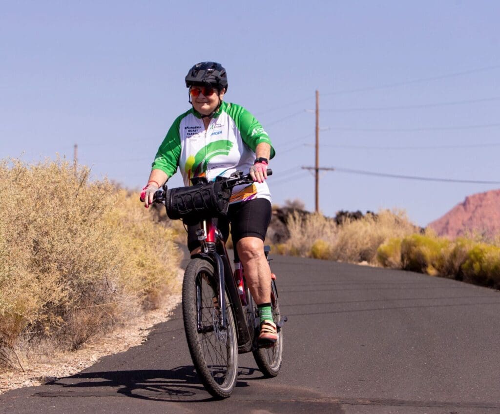 Older adult woman mountain biking on road