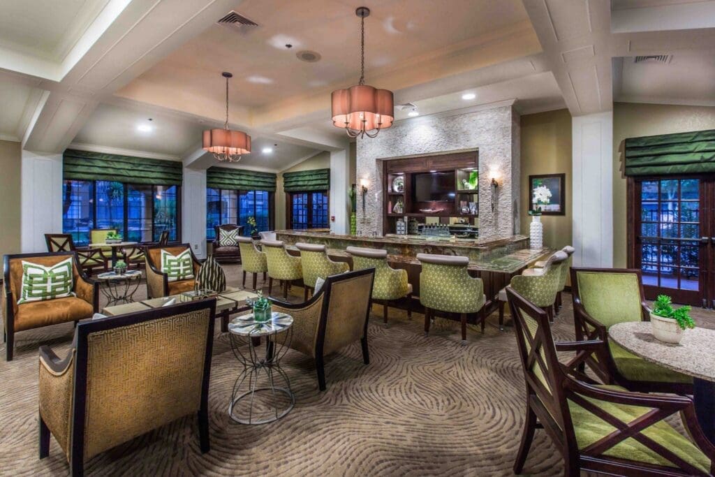 Elegant lounge area featuring stylish seating, a vibrant bar, and large windows, fostering a warm community atmosphere.