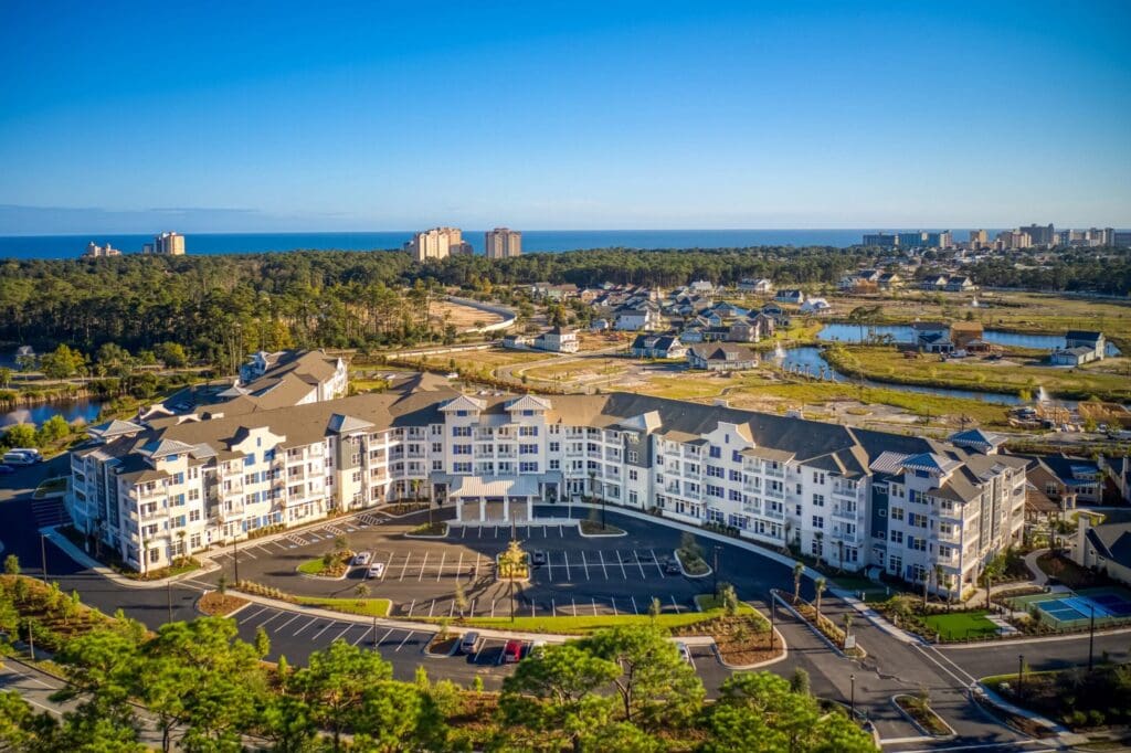 Elegant senior living community with spacious grounds, modern architecture, and serene coastal views.