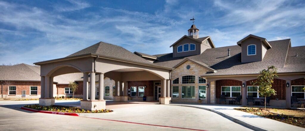 Sophisticated senior living community entrance showcasing elegant architecture and beautifully landscaped surroundings.