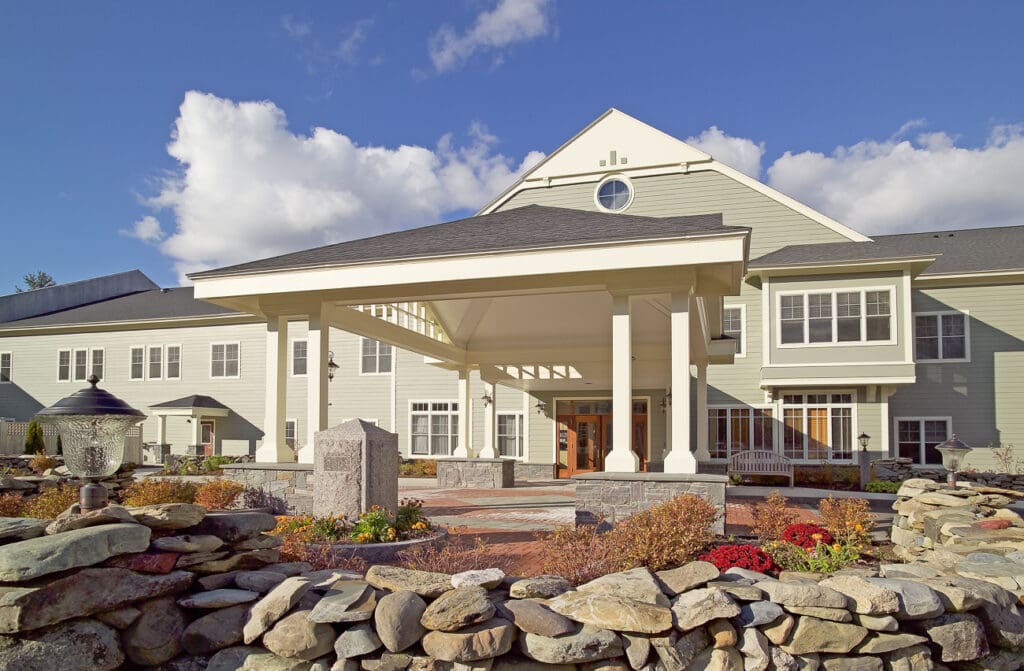 Welcoming entrance of an upscale senior living community featuring elegant architecture and vibrant landscaping.