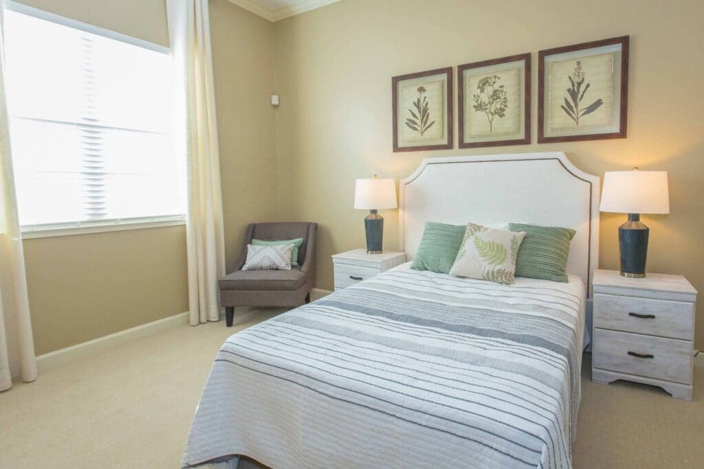 Sage-Desert-Tucson-AZ-2018-June-0095-2048x1365 - Grace Management Bright, inviting bedroom featuring a cozy bed, stylish armchair, and tasteful decor, promoting a serene living environment.