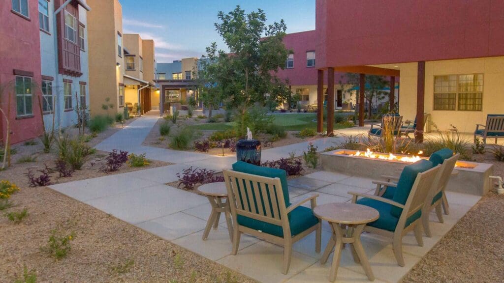 Sage-Desert-Tucson-AZ-2018-June-0659-2048x1152 - Grace Management Serene courtyard with comfortable seating, vibrant landscaping, and a cozy fire feature, inviting relaxation and community.