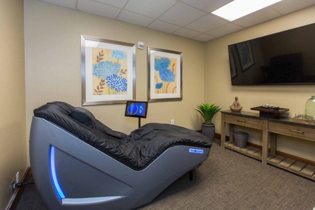 Sage-Desert-Tucson-AZ-2018-June-9982-2048x1365 - Grace Management Serene relaxation room featuring a sleek massage chair, elegant floral artwork, and modern décor for a rejuvenating experience.