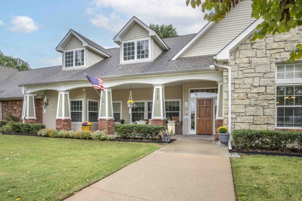 Charming senior living exterior with lush landscaping, inviting entrance, and welcoming ambiance showcasing a vibrant community.