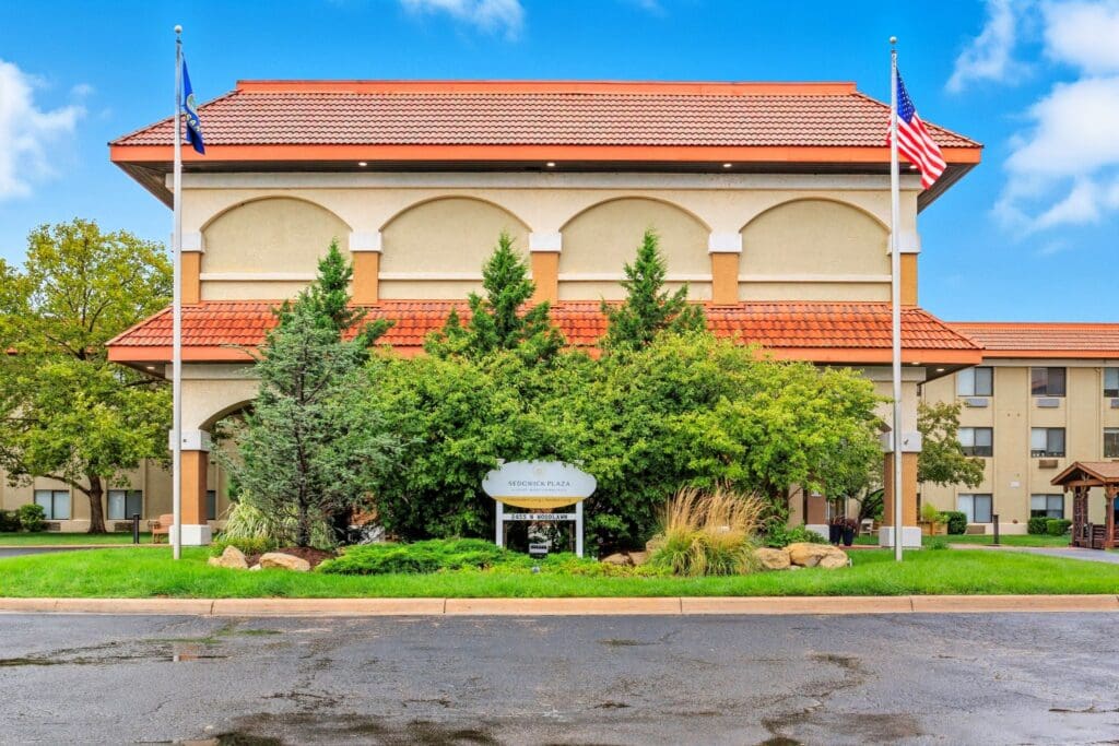 Welcoming exterior of Sedgwick Plaza, featuring lush landscaping, vibrant greenery, and a charming architectural design.