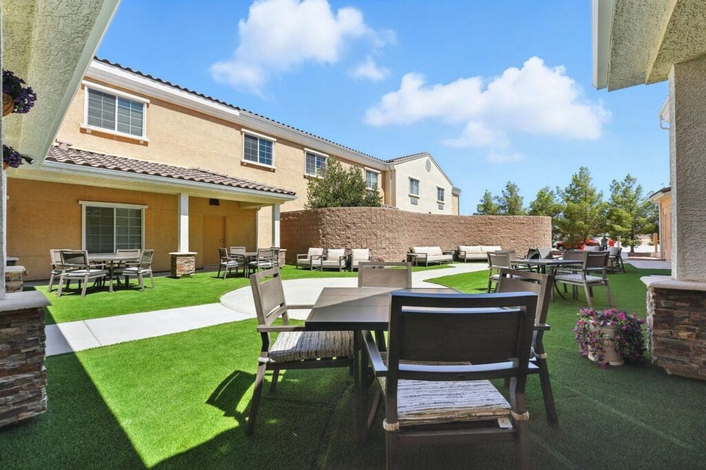 Welcoming outdoor patio with modern furniture and lush greenery, perfect for socializing in a serene, upscale setting.