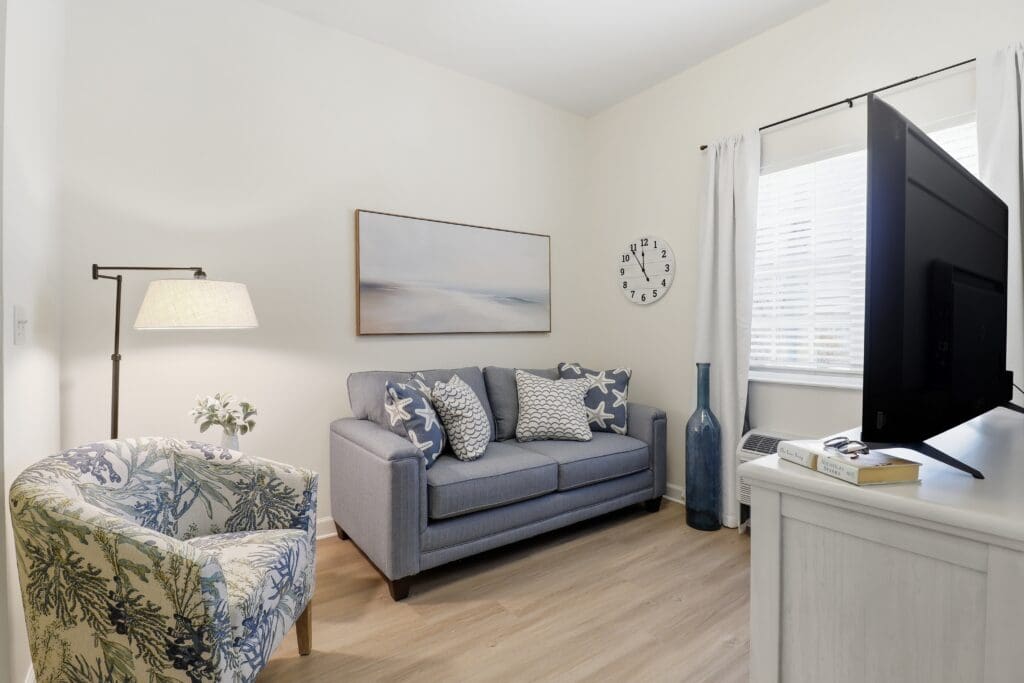 Inviting living space featuring a stylish sofa, vibrant armchair, elegant lamp, and tasteful decor for a warm atmosphere.