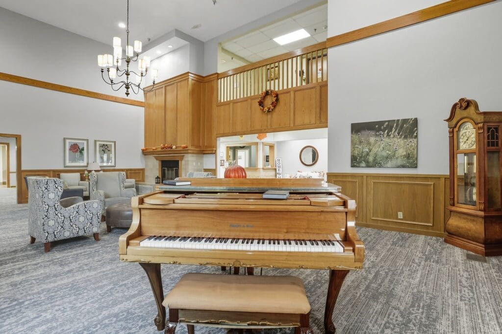 Elegant common area featuring a grand piano, cozy seating, and warm wood accents, fostering a vibrant and inviting atmosphere.