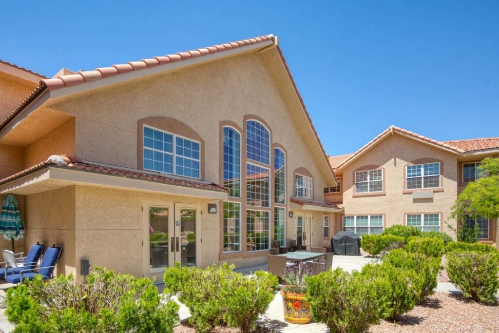 Welcoming exterior of a senior living community featuring beautiful landscaping and upscale outdoor seating areas.