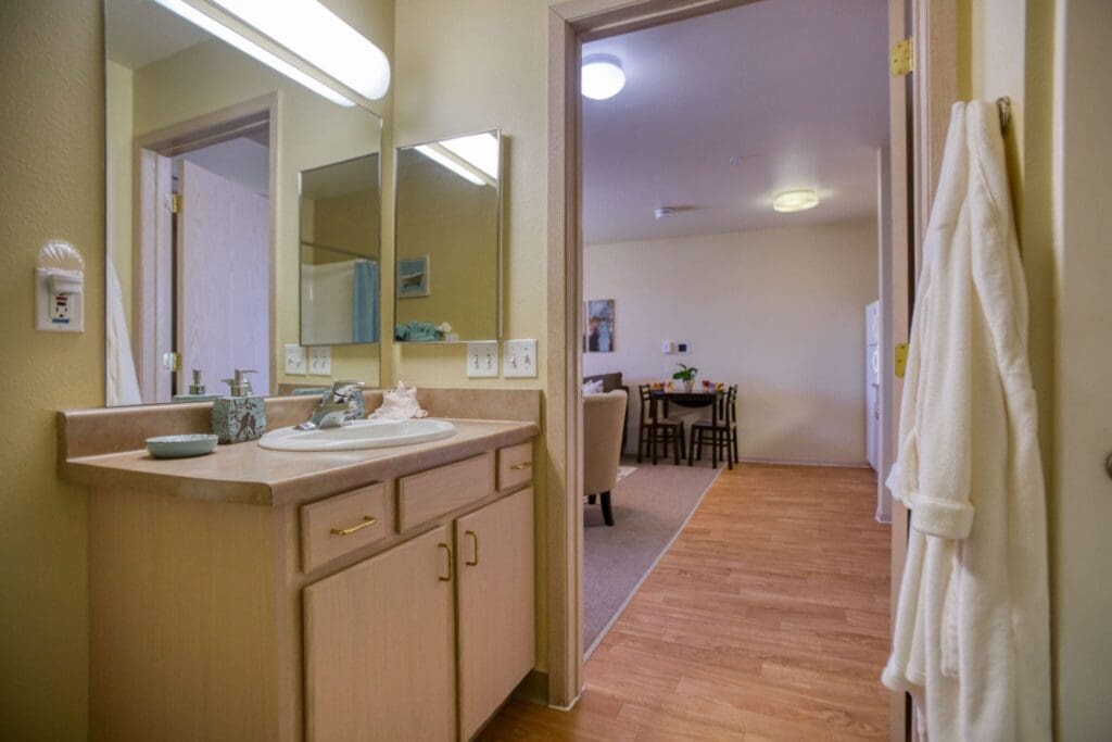 Inviting bathroom setting featuring modern amenities, leading to a cozy dining area with ample natural light.