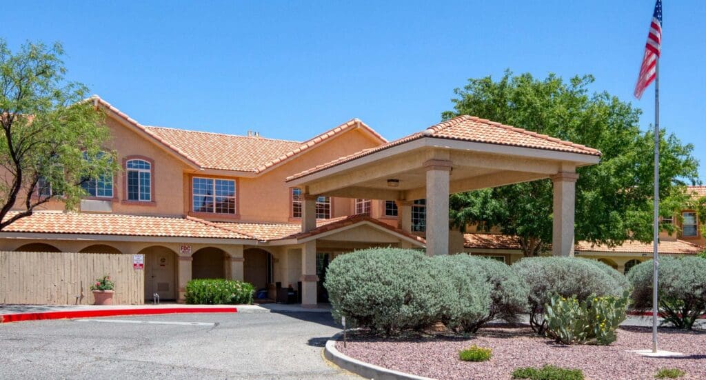 Charming senior living community entrance with vibrant landscaping, welcoming architecture, and a serene atmosphere.