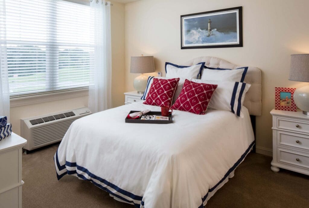Comfortable bedroom featuring a neatly made bed, decorative pillows, and inviting natural light from the window.