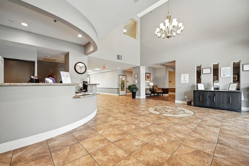 Welcoming lobby featuring a reception desk, elegant chandelier, and comfortable seating, promoting a vibrant senior lifestyle.