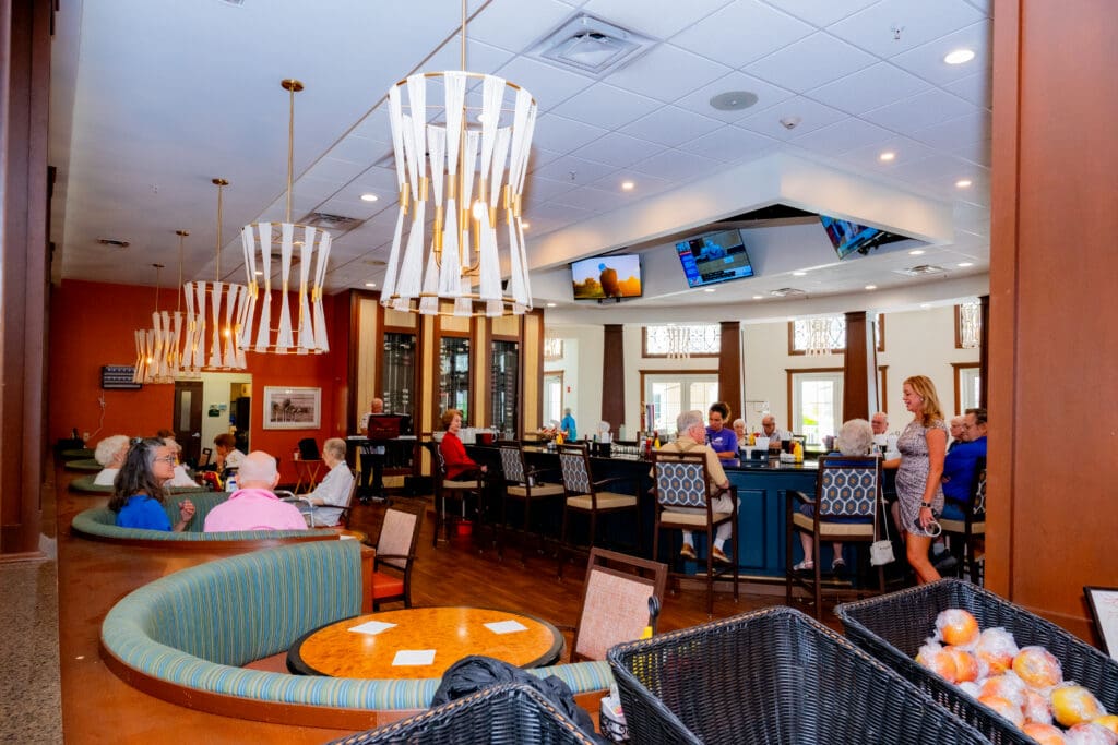 Vibrant gathering area in a senior living community, featuring residents socializing, modern decor, and upscale seating.