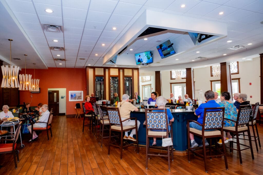 Seniors enjoying social time at a stylish bar with upscale seating, vibrant atmosphere, and attentive staff.