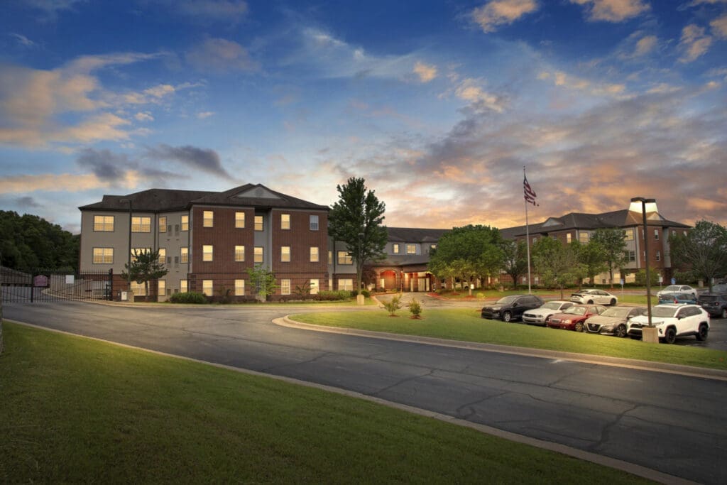 2022-05-26-HomeJab-002_8-dusk-1 - Grace Management Elegant senior living community with modern architecture, landscaped grounds, and a welcoming entrance at dusk.