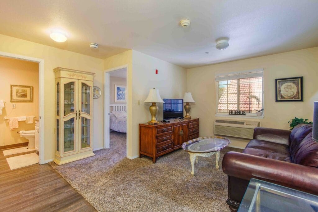2022_LakeHavasu_INT-Model_62-scaled - Grace Management Cozy living space featuring a TV, elegant furniture, and natural light, enhancing a vibrant and comfortable lifestyle.