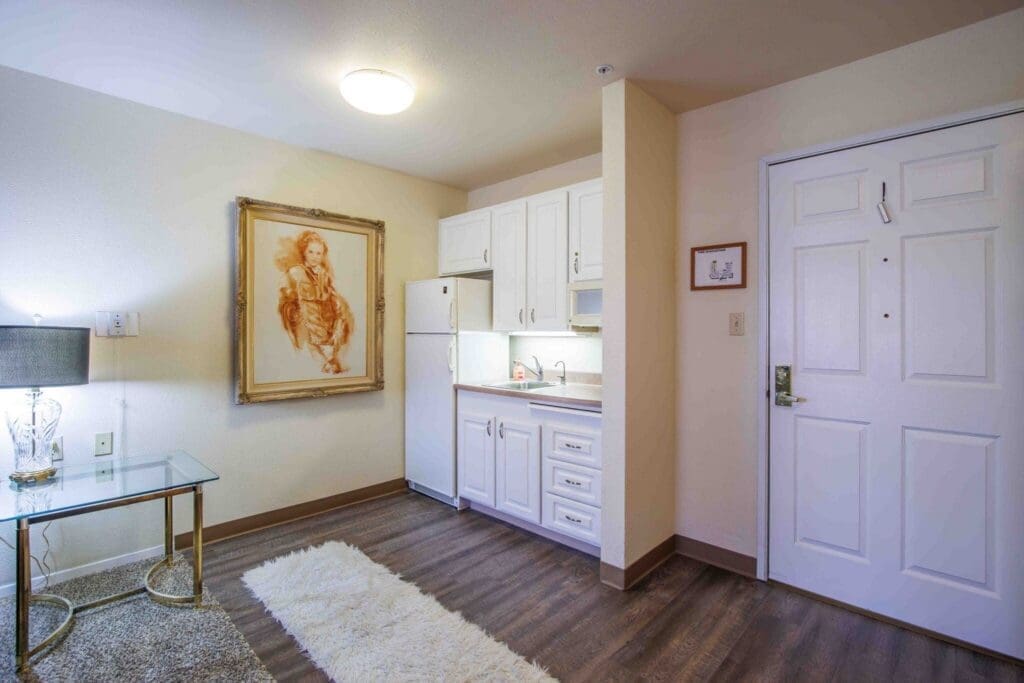 2022_LakeHavasu_INT-Model_68-2048x1365 - Grace Management Stylish senior living suite featuring modern kitchen, elegant decor, and warm lighting for a vibrant lifestyle.