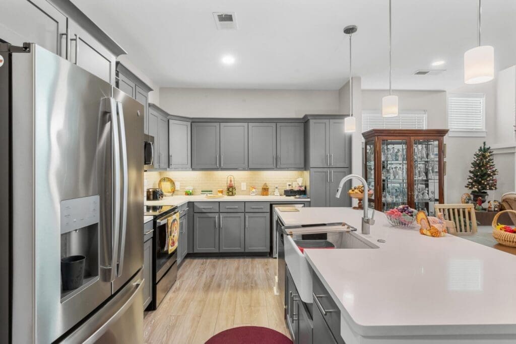 228-2048x1365 - Grace Management Modern kitchen featuring sleek gray cabinetry, stainless steel appliances, and inviting decor, exuding a vibrant lifestyle.