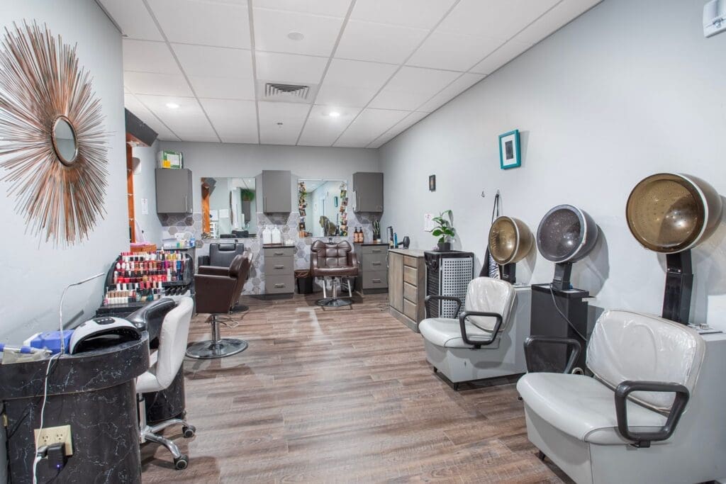Modern salon with elegant styling stations, a nail polish display, and hair dryers, promoting a vibrant and upscale atmosphere.