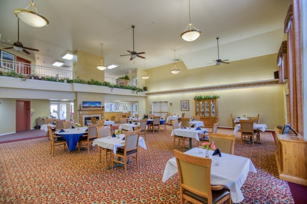 Spacious dining area with elegantly set tables, high ceilings, and warm decor, promoting a vibrant dining experience.