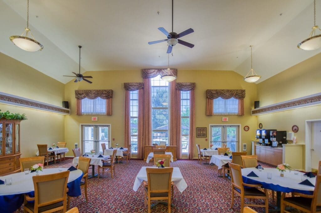 Elegant dining room featuring tables set for meals, large windows, and warm decor, promoting a vibrant community atmosphere.