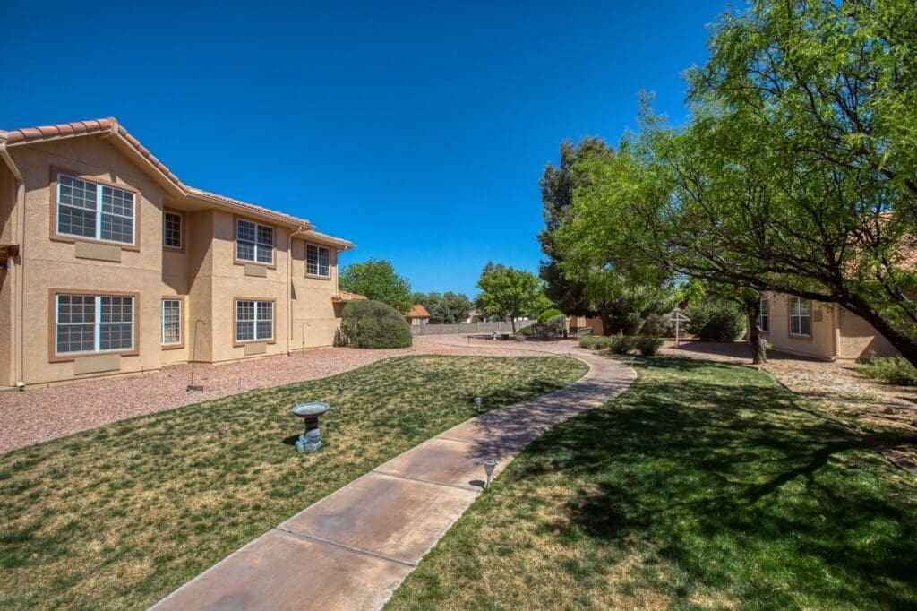 Tranquil exterior view of a senior living community with vibrant greenery, walking paths, and beautifully designed buildings.