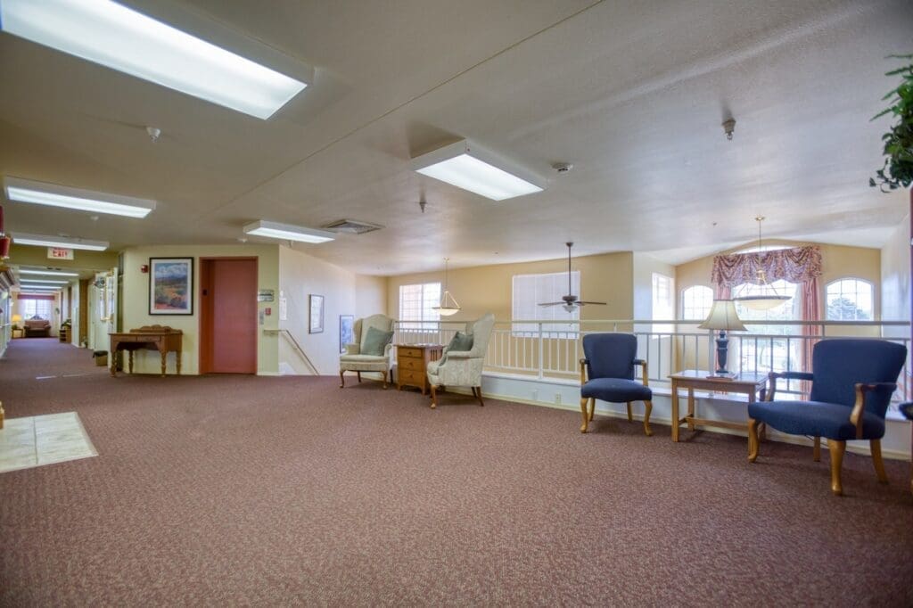 Bright and inviting corridor featuring comfortable seating, elegant decor, and a warm ambiance for vibrant senior living.