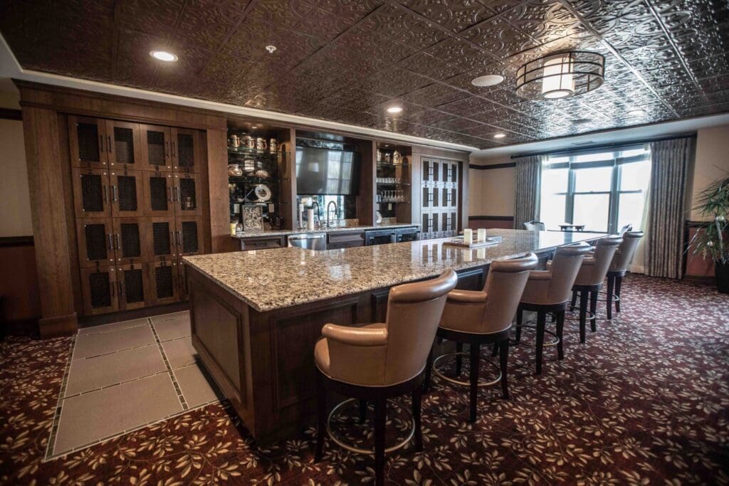 5H8A0553-2048x1365 - Grace Management Elegant lounge featuring a spacious granite bar, plush seating, and upscale decor, inviting social interactions and relaxation.