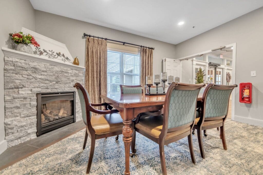 Elegant dining area featuring a wooden table, stylish chairs, and a cozy fireplace, creating an inviting atmosphere.