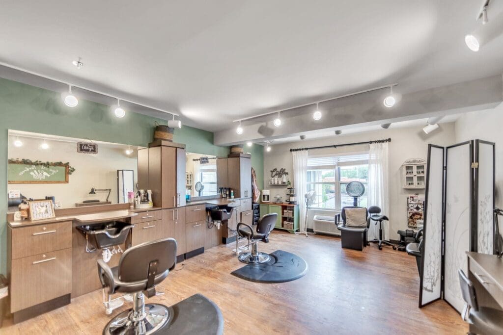 Stylish salon interior featuring modern styling stations, comfortable seating, and warm lighting for an upscale grooming experience.