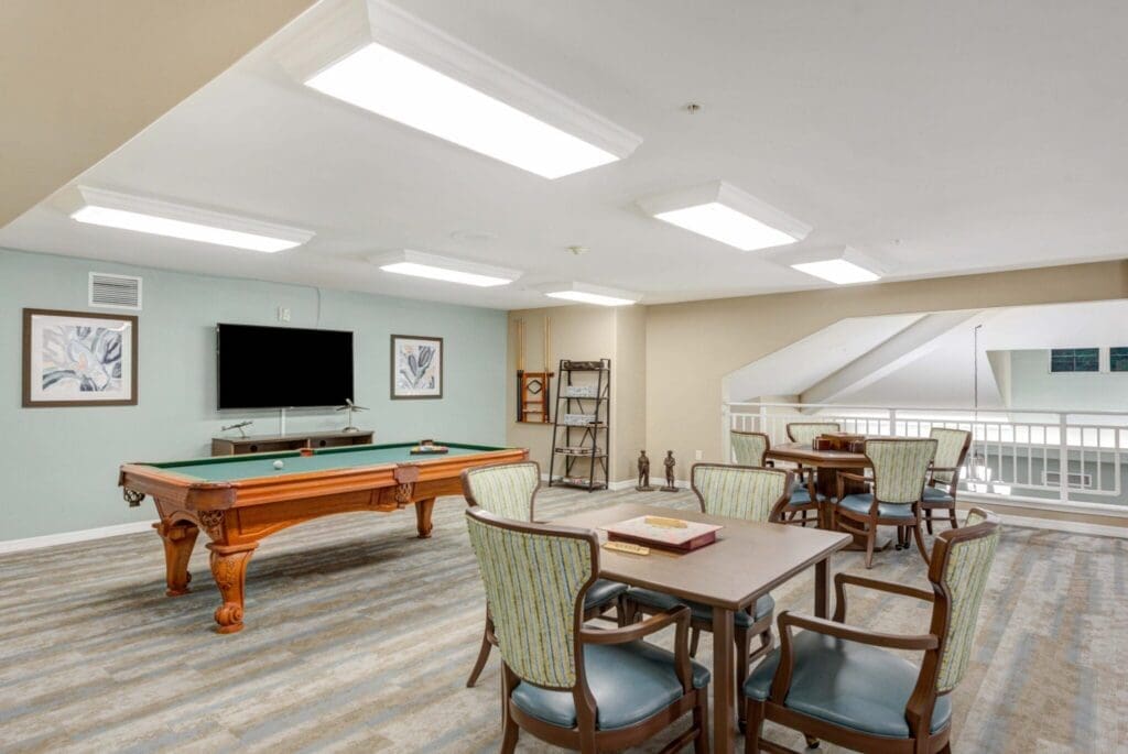 Elegant recreational lounge featuring a billiard table, inviting seating areas, and bright, airy atmosphere for social engagement.