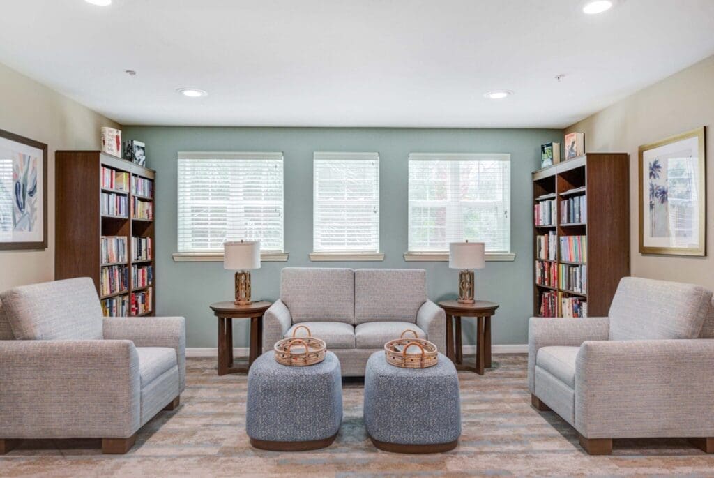 Inviting lounge area with plush seating, bright windows, and bookshelves, fostering a vibrant, welcoming community atmosphere.
