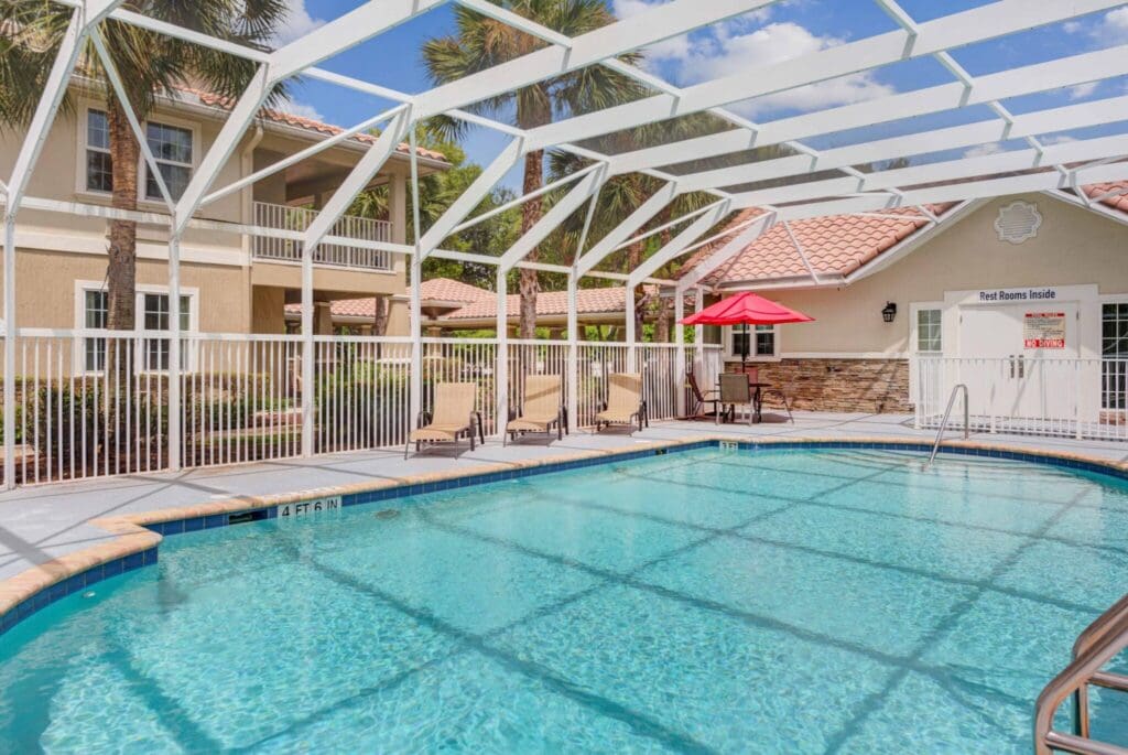 Sparkling pool surrounded by lush greenery and comfortable seating, offering a serene space for relaxation and enjoyment.