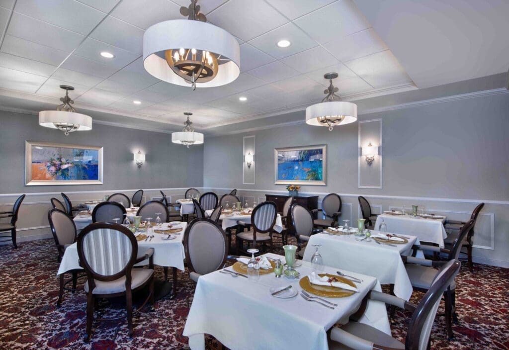 Bridgewater-Dining-Room-1-1-2048x1408 - Grace Management Elegant dining room featuring plush seating, refined table settings, and stylish decor, creating an inviting atmosphere for residents.