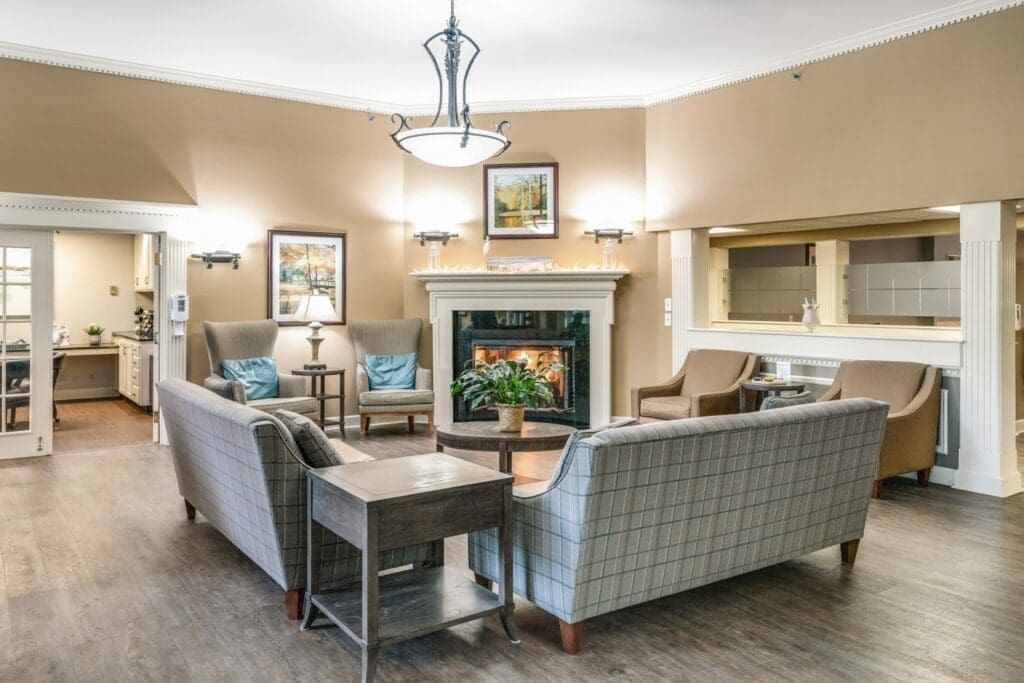 Inviting common area featuring comfortable seating, a cozy fireplace, and warm decor, promoting social interaction and relaxation.