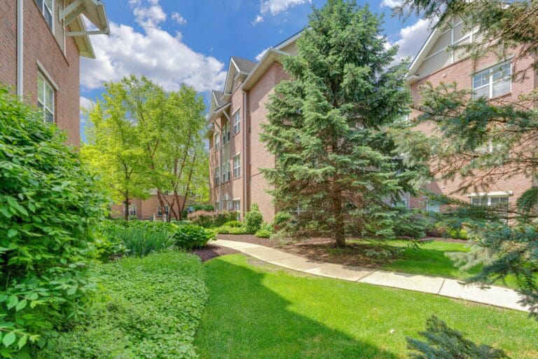 An indoor pool with poolside tables and chairs at Town Village Sterling Heights, a senior living community near Clinton Township, MI.